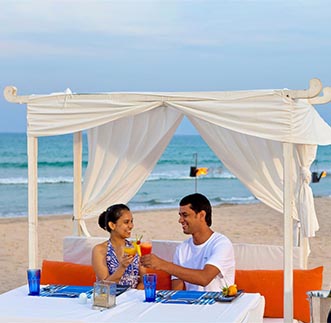 A couple enjoying romantic private dining by the beach 