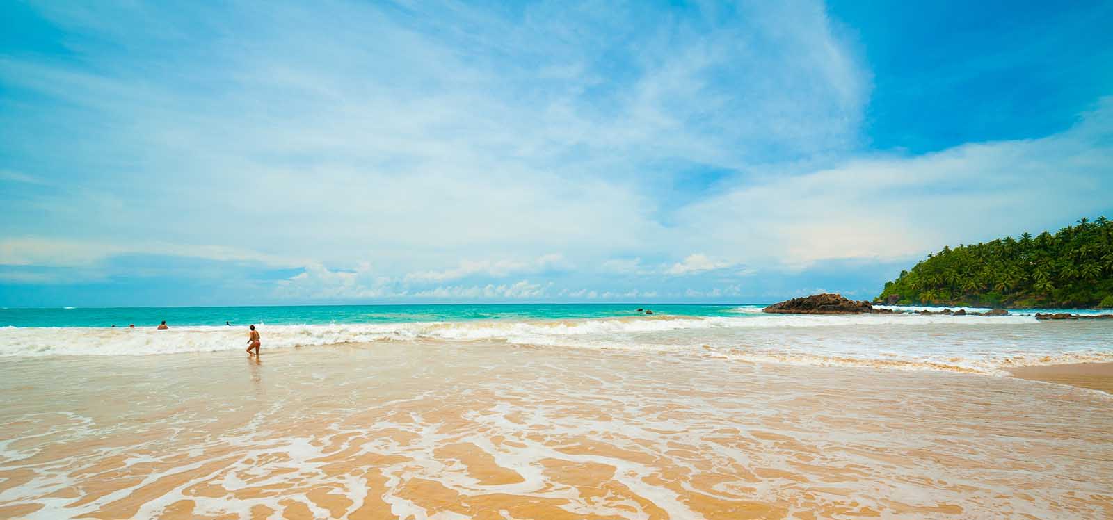 Tourists enjoying the pristine beaches of Sri Lanka